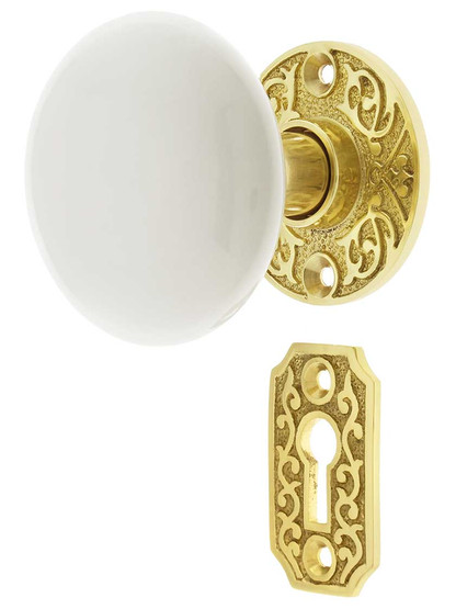 Scroll Rosette Mortise Lock Set with White Porcelain Door Knobs in Polished Brass.
